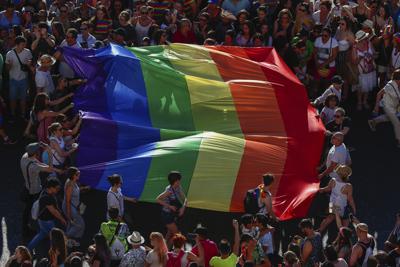 ARCHIVO - En esta foto de archivo del 6 de julio de 2019, los participantes en la marcha anual de orgullo LGBTQ portan la emblemática bandera del arco iris en Madrid, España. El Consejo de Ministros aprobó el martes 29 de junio de 2021 un proyecto de ley que permitirá a personas transgénero mayores de 16 años cambiar su género y nombre en el registro civil sin la intervención de médicos o testigos. (AP Foto/Manu Fernandez)