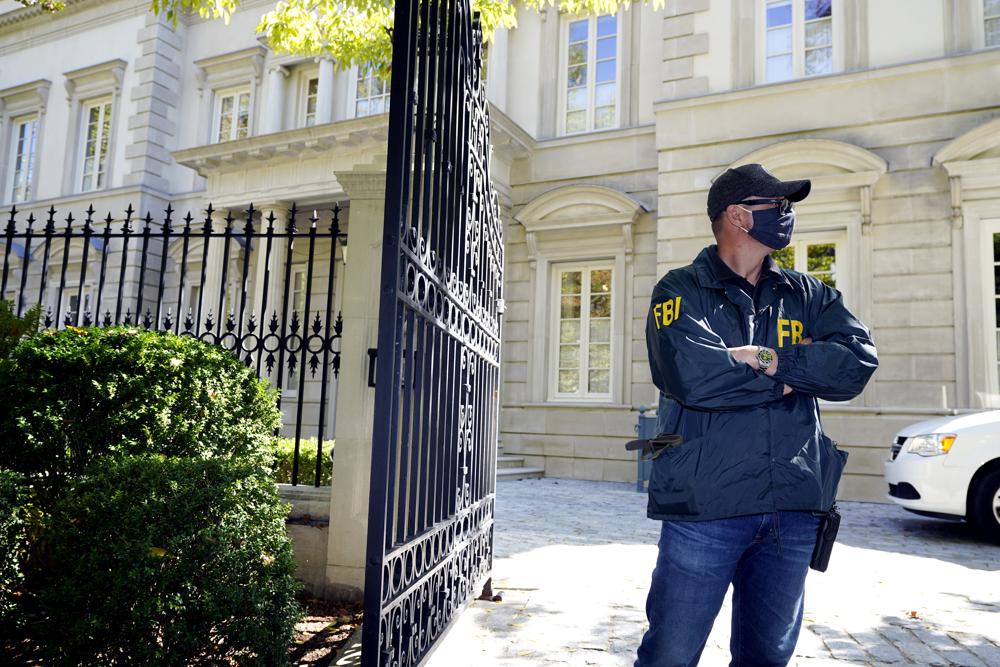 A federal agent stands in front of a home of Russian oligarch Oleg Deripaska, Tuesday, Oct. 19, 2021 in Washington. An agency spokesperon says FBI agents were at a home in Washington connected to Deripaska to carry out