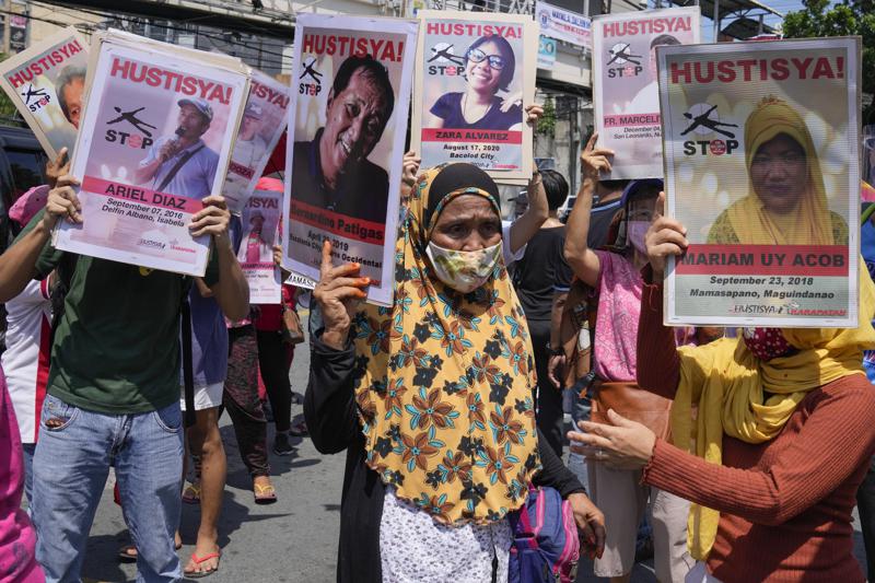 Manifestantes portan retratos de presuntas víctimas de asesinatos extrajudiciales durante un acto frente al palacio Malacanang en Manila, Filipinas, miércoles 30 de julio de 2021. (AP Foto/Aaron Favila)