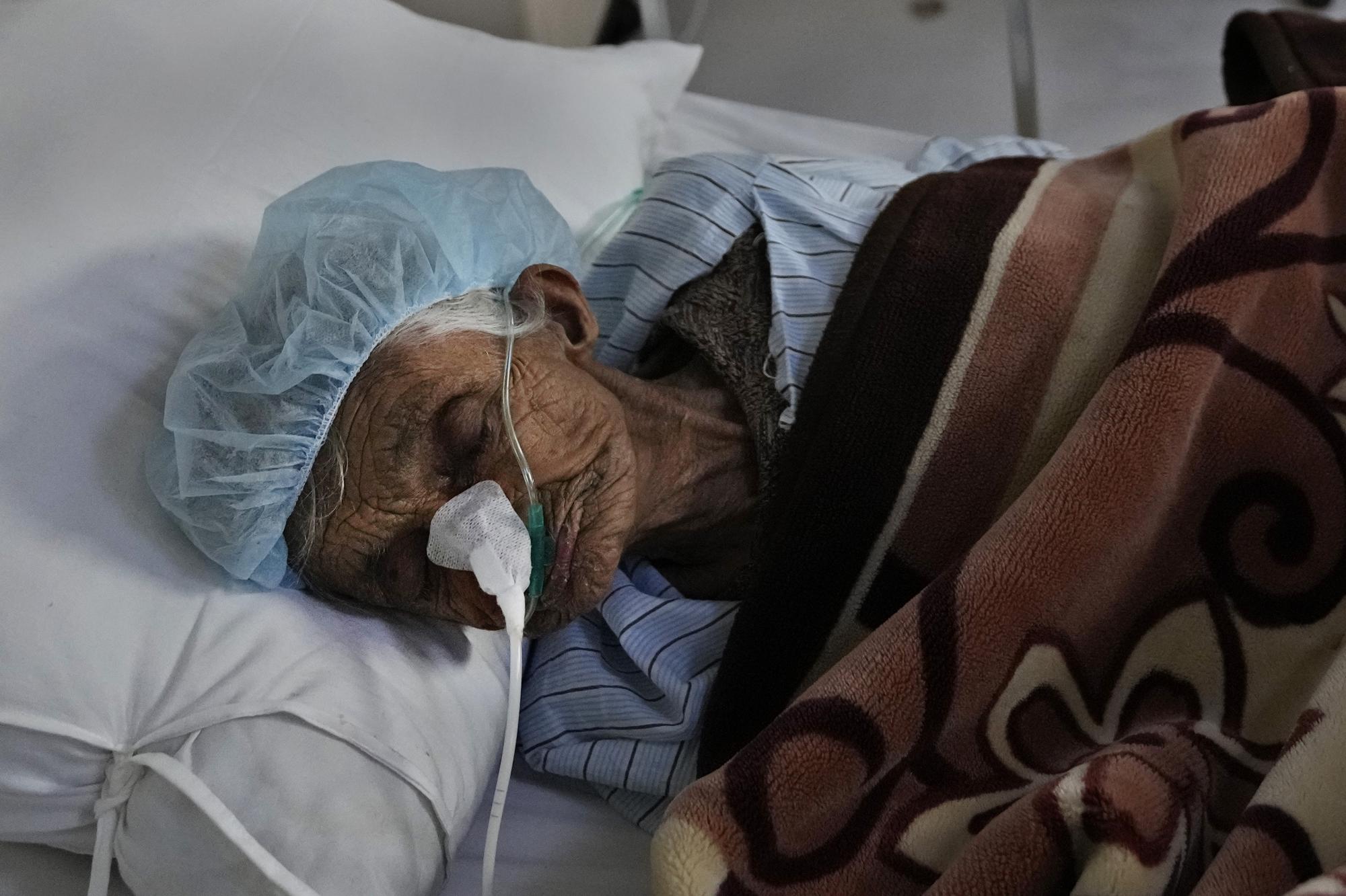 An Afghan patient infected with COVID-19 lies on a bed in the intensive care unit of the Afghan Japan Communicable Disease Hospital, in Kabul, Afghanistan, Monday, Feb. 7, 2022. All but five of 38 COVID treatment hospitals that once operated in Afghanistan have been forced to close for lack of doctors, medicines and even heat. This comes as an economically devastated Afghanistan last week experienced a 67% increase in the numbers of reported COVID cases, according to the World Health Organization. (AP Photo/Hussein Malla)