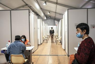 Gente acude a vacunarse contra el COVID-19 en el centro de vacunación del Ayuntamiento de París, Francia, el viernes 6 de agosto de 2021. (AP Foto/Adrienne Surprenant)