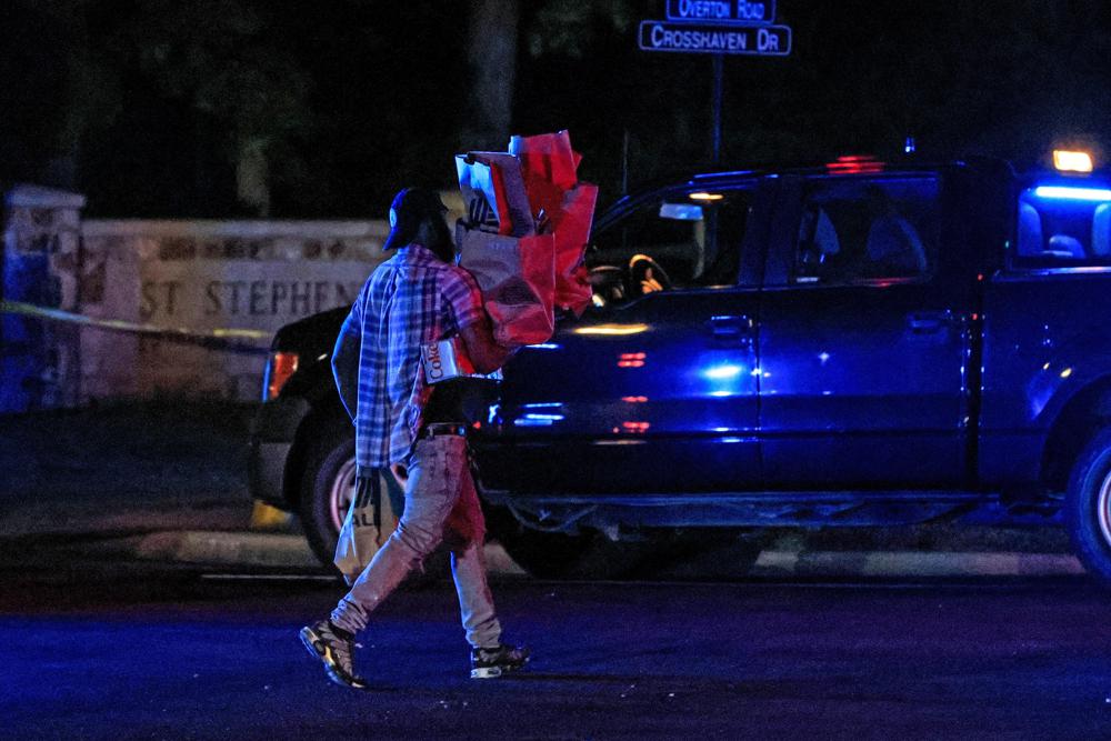 Los residentes caminan a casa desde una tienda local mientras la policía bloquea el área después de un tiroteo en la Iglesia Episcopal de Saint Stevens el jueves 16 de junio de 2022 en Vestavia, Alabama. (AP Photo/Butch Dill)