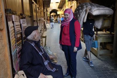 Hania Zaatari, center, who is an independent candidate in the upcoming parliamentary elections tells a man that fixing Lebanon's devastating economic crisis is her top priority, at the old souk, in  Sidon, Lebanon, April 9, 2022. The May 15 nationwide vote is the first since Lebanon's economy took a nosedive and an August 2020 explosion at Beirut's port killed more than 200 and destroyed parts of the capital. Lebanon's various disasters have fueled anger at Lebanon's political elite, but few see any hope that elections will dislodge them. (AP Photo/Hussein Malla)