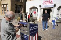 FILE - A voter submits a ballot in an official drop box during early voting in Athens, Ga., on Oct. 19, 2020. The widespread use of absentee ballot drop boxes during the 2020 election was largely trouble-free, contrary to claims made by former President Donald Trump and his Republican allies. An Associated Press survey of state election officials across the U.S. revealed no problems that could have affected the results, including from fraud, vandalism or theft. (AP Photo/John Bazemore, File)