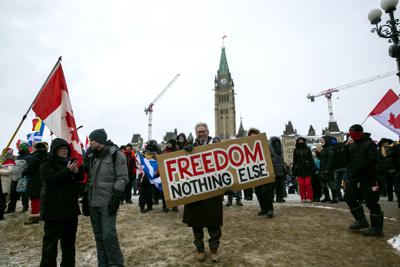 Don Stephens, de 65 años, diseñador gráfico retirado, sostiene un cartel ante el Parlamento para apoyar a los camioneros reunidos con el fin de protestar contra las órdenes de vacunación y otras restricciones para combatir al COVID-19, el sábado 12 de febrero de 2022, en Ottawa, Ontario. El letrero dice: "Libertad, nada más". (AP Foto/Ted Shaffrey)