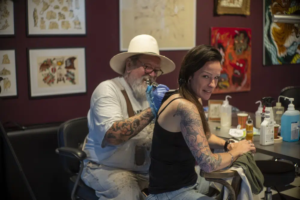 Henk Schiffmacher's needle whirrs as he tattoos the lines of am elephant on Lilian Rachmaran's back in Amsterdam, Monday, June 19, 2023. "Highbrow to lowbrow" is how the famous Dutch tattoo artist describes his latest project, inking drawings by Rembrandt van Rijn onto the skin of visitors to the building the Golden Age master once called home. (AP Photo/Peter Dejong)