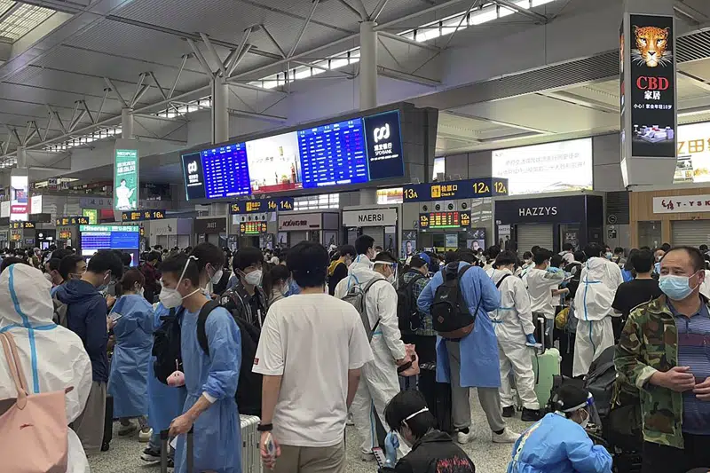 In this photo taken May 2022 and released by Leah Zhang, passengers some wearing protective overalls wait for their train at a train station in Shanghai. Over 26 million people in Shanghai were confined for two months in one of the country's strictest and most visible lockdowns. (Leah Zhang via AP)