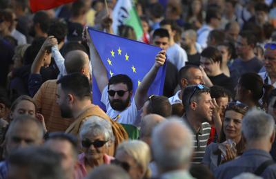 Un manifestante progubernamental sostiene la bandera de la UE durante una manifestación en apoyo del actual gobierno búlgaro cerca del edificio del Parlamento en Sofía, el martes 21 de junio de 2022. (AP Foto/Valentina Petrova)