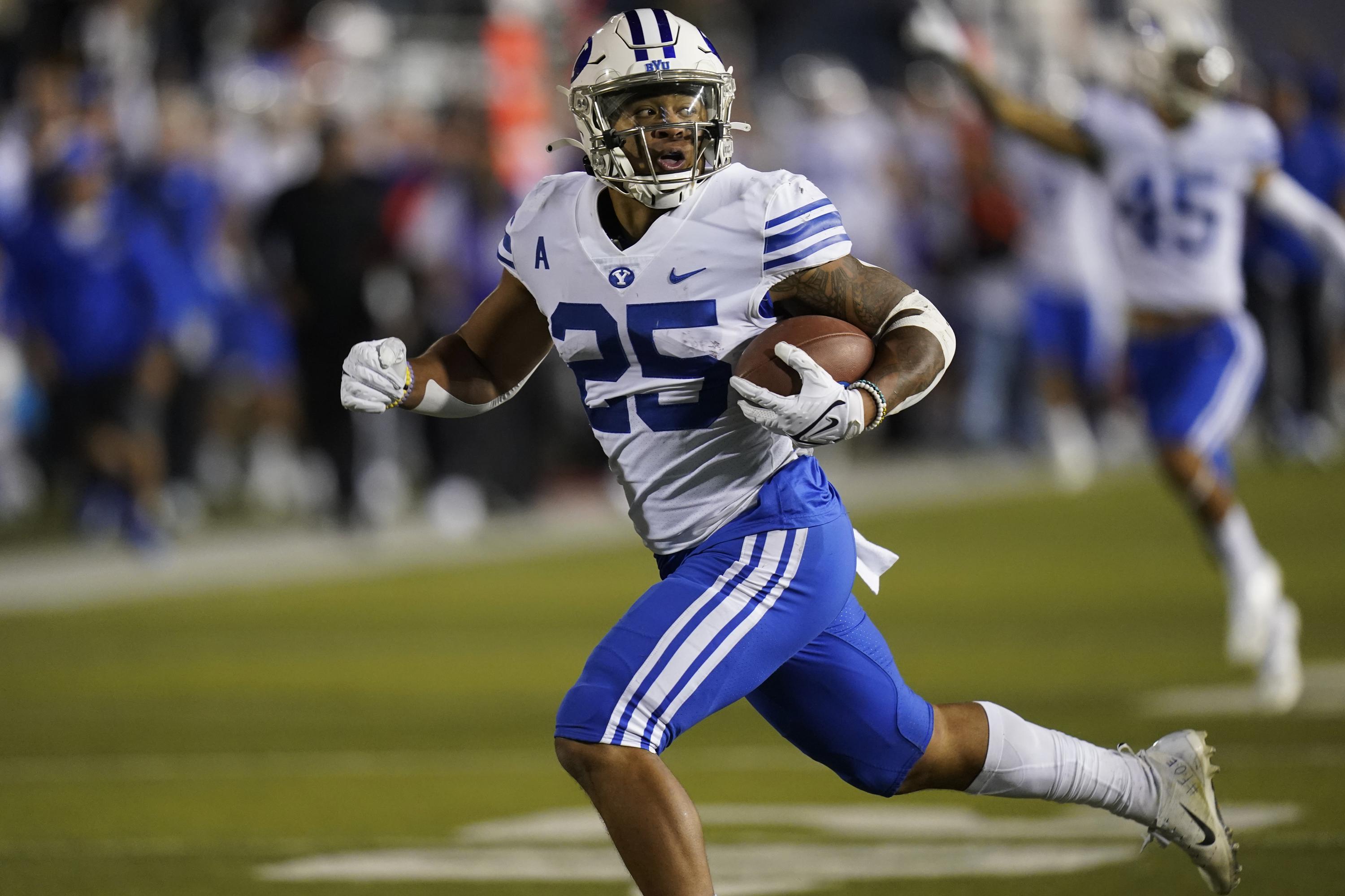 Tyler Allgeier runs past Utah State defenders for a touchdown.