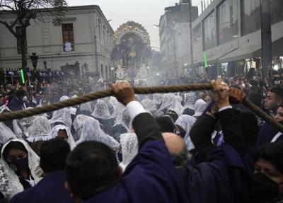 Mujeres con la cabeza cubierta por velos queman incienso durante una procesión que marca la festividad del Señor de los Milagros en Lima, Perú, el martes 18 de octubre de 2022. Después de dos años de restricciones por la pandemia, el santo patrón de la nación ha regresado a las calles para la procesión anual. (Foto AP/Martín Mejía)