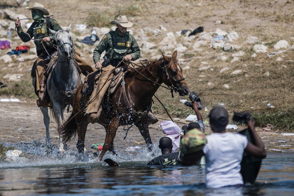 FILE - Mounted U.S. Border Patrol agents attempt to contain migrants as they cross the Rio Grande from Ciudad Acuña, Mexico, into Del Rio, Texas, Sept. 19, 2021. Border Patrol agents on horseback engaged in unnecessary use of force against non-threatening Haitian immigrants but didn't whip any with their reins, according to a federal investigation of chaotic scenes along the Texas-Mexico border last fall. (AP Photo/Felix Marquez, File)