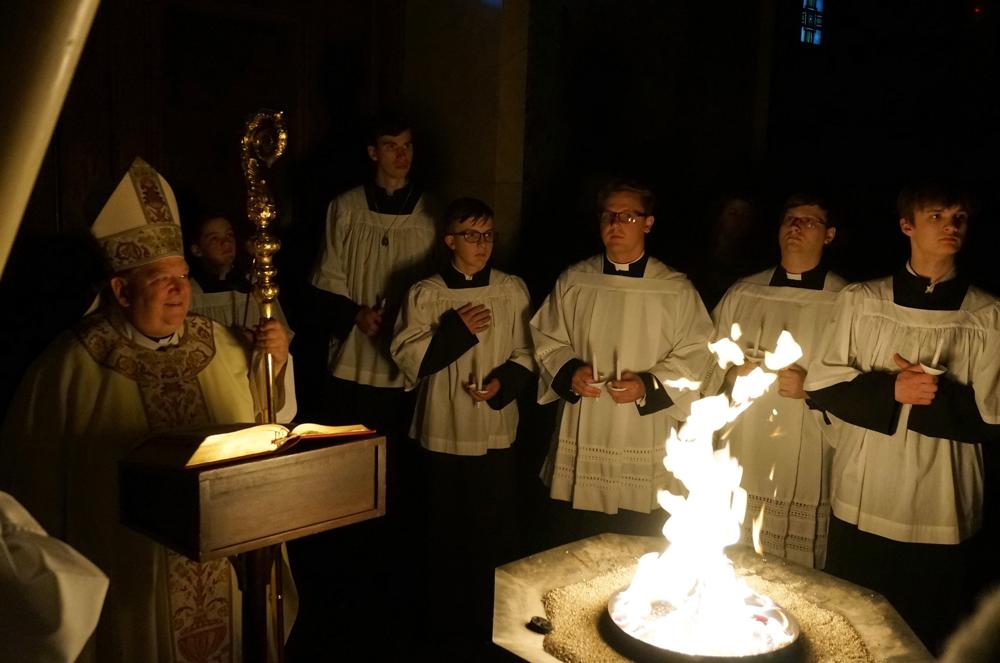 Archbishop Bernard Hebda, left, smiles before blessing the fire and the Paschal candle at the Cathedral of St. Paul in St. Paul, Minn., on Saturday, April 16, 2022. For many U.S. Christians, this weekend marks the first time since 2019 that they will gather in person on Easter Sunday, a welcome chance to celebrate one of the year's holiest days side by side with fellow congregants. (AP Photo/Giovanna Dell'Orto)