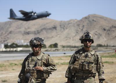 En esta imagen difundida por el Departamento de Defensa, dos soldados asignados a la 1ra Brigada de Combate de la 82da División Aérea realizan una inspección de seguridad mientras un Hercules C-130 despega durante la operación de evacuación, el miércoles 25 de agosto de 2021, en Kabul, Afganistán. (Department of Defense via AP)