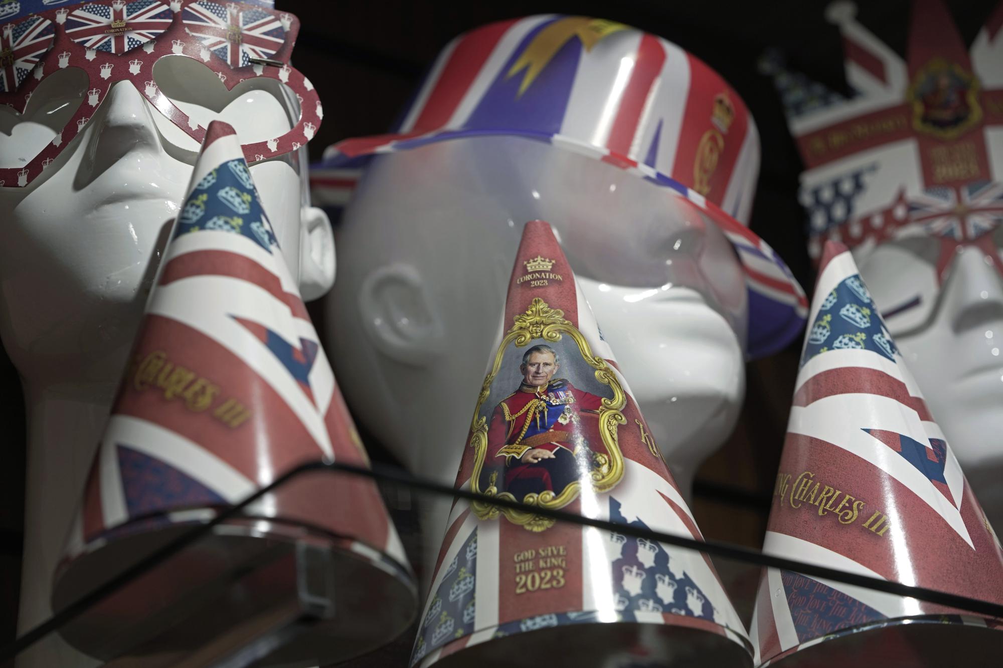 Souvenirs are displayed for sale in a gift shop ahead of King Charles III's Coronation in London, Monday, April 24, 2023. The May 6 coronation is luring royal fans and far-flung visitors fascinated by the ceremonial spectacle — and drama — of the monarchy and eager to experience a piece of British history. Tour companies, shops and restaurants are rolling out the red carpet, whether it's a decked-out bus tour of London's top sights boasting high tea or merchandise running from regal to kitschy. (AP Photo/Kin Cheung)
