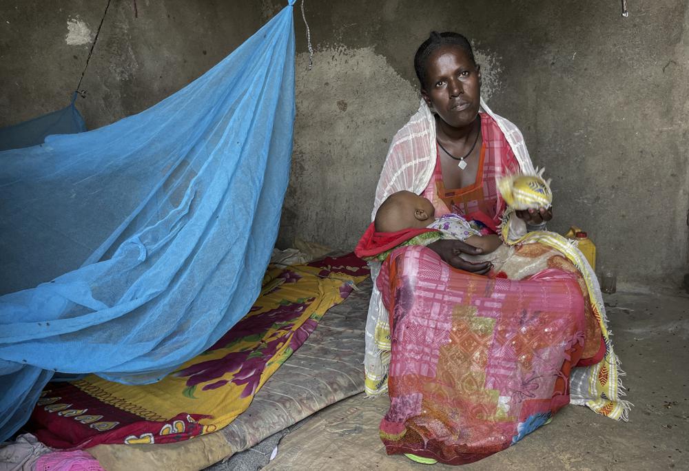 Letemariam, a mother of six, sits with her baby who was born in a former camp for Eritrean refugees now used by internally-displaced Tigrayans, after escaping fighting in her home town in western Tigray, in the Hitsats camp in the Tigray region of northern Ethiopia Saturday, Aug. 21, 2021. Letemariam was 7 months pregnant when her village was attacked and she and her five children fled on foot with only the clothes on their backs. (Claire Nevill/WFP via AP)