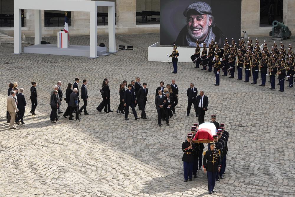 Republican Guards carry the coffin of Jean-Paul Belmondo during a tribute ceremony at the Hotel des Invalides, Thursday, Sept.9 2021 in Paris. France is paying respects Thursday to screen legend Jean-Paul Belmondo with a solemn ceremony led by the president and a public viewing at Napoleon's final resting place. (AP Photo/Michel Euler)