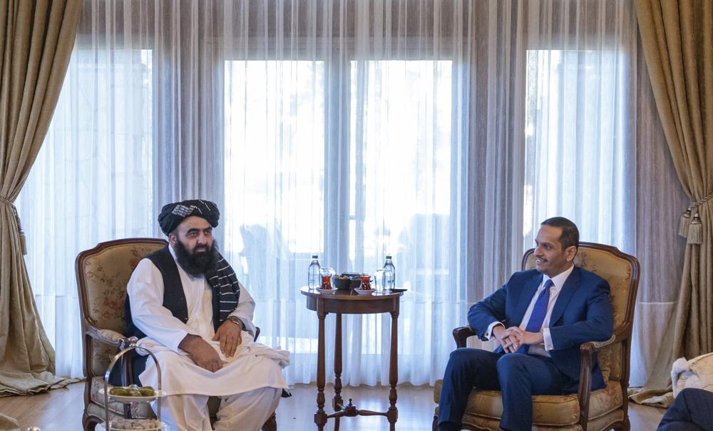 In this handout photo released by Qatar Ministry of Foreign Affairs, Qatar's Foreign Minister Sheikh Mohammed bin Abdulrahman Al Thani, right, meets with Taliban Foreign Minister Amir Khan Muttaqi during the Antalya Diplomacy Forum in Turkey, Friday, March 11, 2022. Qatar on Friday hosted a meeting that saw Taliban's foreign minister and an American diplomat for Afghanistan in the same room during a summit in Turkey. (Qatar Ministry of Foreign Affairs via AP)