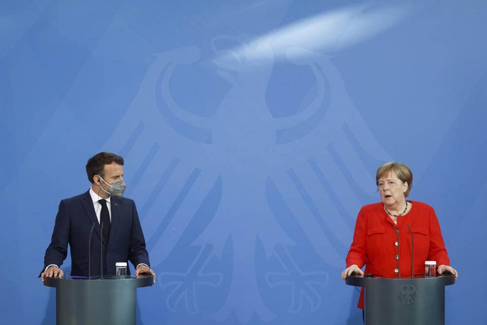 German Chancellor Angela Merkel, right, and French President Emmanuel Macron give a joint statement to journalists, at the chancellery in Berlin, Germany, Friday June 18, 2021. (Axel Schmidt/Pool via AP)