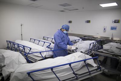 Un trabajador sanitario apunta la información de pacientes fallecidos por complicaciones derivadas del COVID-19, en la morgue del Hospital Regional de Zipaquira, Colombia, el 28 de junio de 2021. Colombia se ha convertido en uno de los últimos focos de la pandemia ante una tercera ola de contagios y el repunte de los decesos. (AP Foto/Iván Valencia)