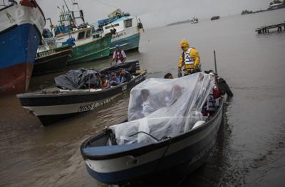 Varias personas salen del puerto en bote para regresar a sus comunidades en medio de la lluvia generada por la tormenta tropical Bonnie, el 1 de julio de 2022, en Bluefields, Nicaragua. (AP Foto/Inti Ocon)
