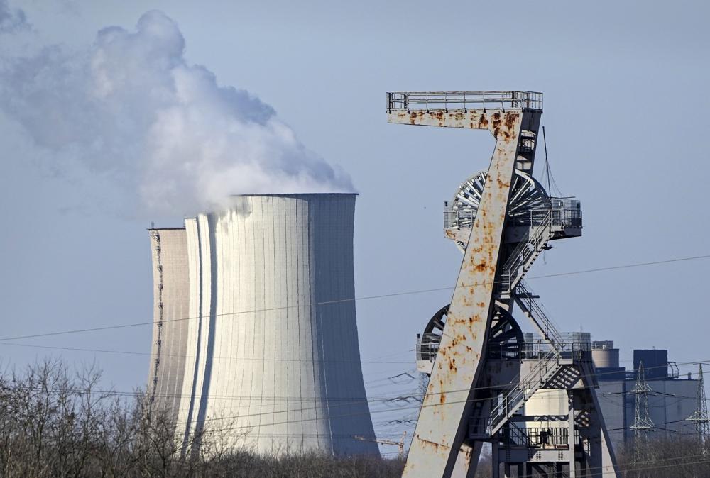 FILE - A winding tower of a closed coal mine rusts in front of a coal-fired power station Gelsenkirchen, Germany, Tuesday, March 8, 2022. Compared to the U.S., the 27-member European Union faces much stronger direct economic consequences than does the U.S. from Russia’s invasion of Ukraine and the resulting sanctions _ and that’s true above all when it comes to the oil and gas that fuels vehicles and keeps the heat and the lights on. (AP Photo/Martin Meissner, File)