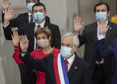 El presidente de Chile, Sebastián Piñera, al centro, y miembros de su gabinete, saludan mientras posan para una foto grupal oficial en el palacio presidencial de La Moneda en Santiago, Chile, el martes 1 de junio de 2021. (AP Foto/Esteban Felix)