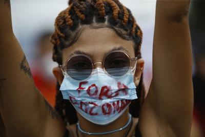 Una mujer usa una mascarilla con el mensaje en portugués "Fuera Bolsonaro" durante una protesta contra el manejo de la pandemia del coronavirus del presidente Jair Bolsonaro en Río de Janeiro, Brasil, el sábado 19 de junio de 2021. (AP Foto/Bruna Prado)
