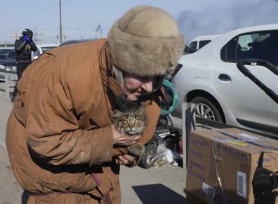 Una anciana lleva a su gato mientras huye de su ciudad natal en el camino hacia Kiev, en la ciudad de Irpin, a unos 25 km (16 millas) al noroeste de Kiev, el sábado 12 de marzo de 2022. Los suburbios del noroeste de Kiev, como Irpin y Bucha, han estado soportando bombardeos y bombardeos rusos durante más de una semana, lo que ha llevado a los residentes a abandonar sus hogares. (AP Foto/Efrem Lukatsky)