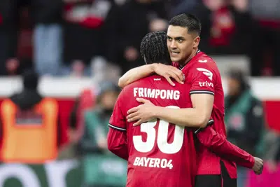 Nadiem Amiri de Leverkusen, a la derecha, celebra anotar con su compañero de equipo Jeremie Frimpong durante el partido de fútbol de la Bundesliga entre Bayer Leverkusen y RB Leipzig en BayArena, Leverkusen, Alemania, el domingo 23 de abril de 2023. (Marius Becker/dpa vía AP)