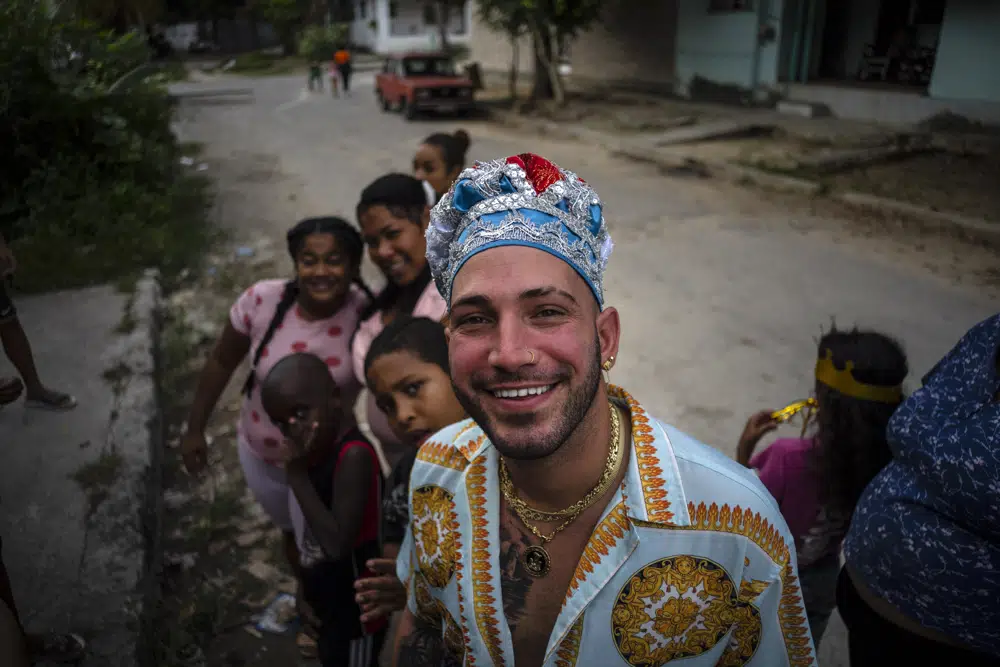 Mandy Arrazcaeta, gekleidet für eine Santería-Zeremonie, lächelt in die Kamera vor seinem Haus in Havanna, Kuba, Sonntag, 13. November 2022. | Bildquelle: AP © AP Photo/Ramon Espinosa | Bilder sind in der Regel urheberrechtlich geschützt