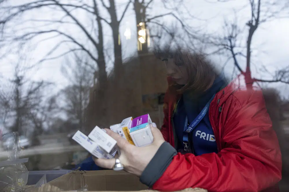 Una voluntaria médica de FRIDA Ukraine busca medicamentos para un paciente mientras presta atención médica especializada a civiles en la localidad de Khrestysche, en la región de Donetsk, Ucraia, el domingo 19 de marzo de 2023. (AP Foto/Evgeniy Maloletka)