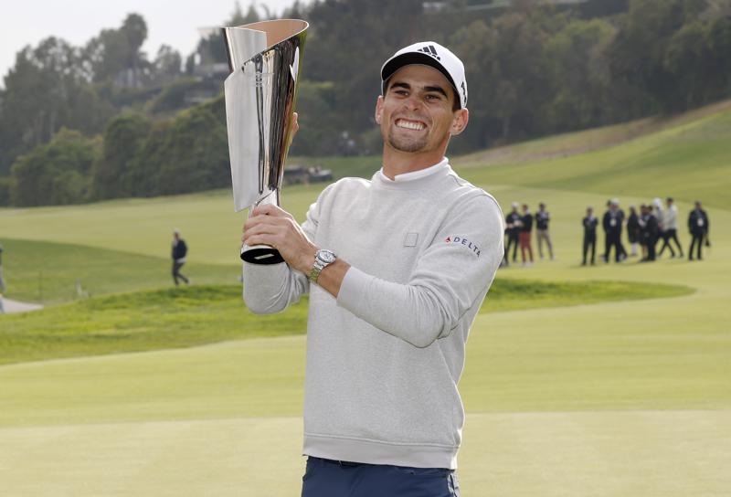 Joaquin Niemann, of Chile, reacts with his trophy on the 18th green after winning the Genesis Invitational golf tournament at Riviera Country Club, Sunday, Feb. 20, 2022, in the Pacific Palisades area of Los Angeles. (AP Photo/Ryan Kang)