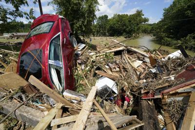 Un auto se encuentra entre los escombros que fueron arrasados por las lluvias y terminaron contra un puente el domingo 22 de agosto de 2021, en Waverly, Tennessee. (AP Foto/Mark Humphrey)