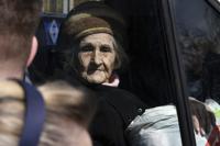 An elderly woman sits in a bus as civillians are evacuated, in Kramatorsk, Ukraine, Saturday, April 9, 2022. (AP Photo/Andriy Andriyenko)