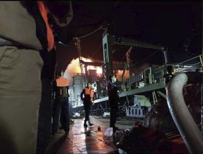 En esta imagen distribuida por Asriran.com el miércoles 2 de junio de 2021, personal en el barco de apoyo de la armada iraní Kharg, después de que el buque se incendiara en el Golfo de Omán. El barco más grande de la armada iraní ardió y más tarde se hundió el miércoles en el Golfo de Omán bajo circunstancias que no estaban claras, según agencias de noticias semioficiales iraníes. (Asriran.com via AP)