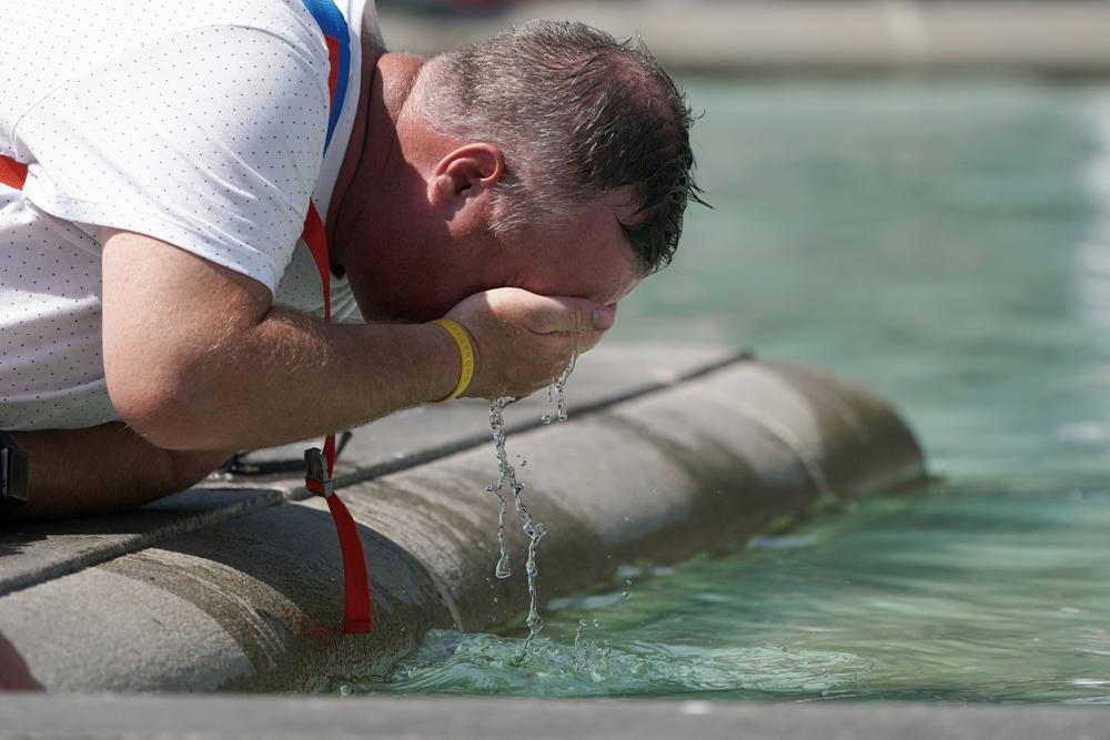 A man refreshes his face at a fountain in Trafalgar Square in central London, Tuesday, July 19, 2022. Britain shattered its record for highest temperature ever registered Tuesday, with a provisional reading of 39.1 degrees Celsius (102.4 degrees Fahrenheit), according to the country's weather office — and the heat was only expected to rise. (Aaron Chown/PA Wire/PA via AP)