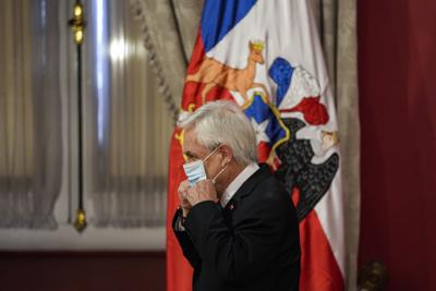 El presidente de Chile, Sebastián Piñera, se vuelve a poner la máscara en medio de la pandemia de COVID-19, luego de anunciar un estado de emergencia en las regiones sureñas de La Araucanía y Biobío, en el palacio presidencial de La Moneda en Santiago, Chile, el martes 12 de octubre de 2021. (AP Foto/Esteban Felix)