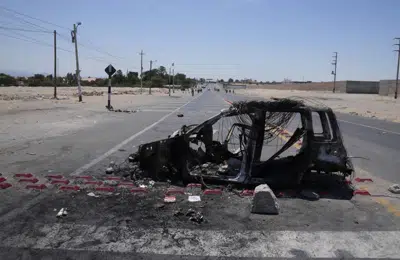 Un vehículo quemado bloquea la autopista Panamericana durante las protestas contra el gobierno de la presidenta Dina Boluarte y del Congreso en Ica, Perú, el viernes 6 de enero de 2023. Las protestas se mantienen despué de la destitución del predecesor de Boluarte, Pedro Castillo, por intentar disolver el Congreso. (AP Foto/Martin Mejía)