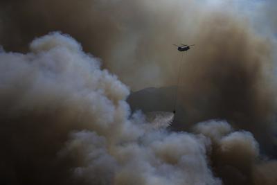 Un helicóptero participa en la operación de extinción de incendios en Koycegiz, Mugla, Turquía, el lunes 9 de agosto de 2021. (AP Foto/Emre Tazegul)