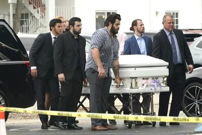 Un féretro decorado con listones color azul y blanco. y que contiene los restos de Lucia y Emma Guera, es llevado por Marcus Guara y su familia para el servicio funerario en la iglesia de St. Joseph, el martes 6 de julio de 2021, en Miami Beach, Florida. (AP Foto/Lynne Sladky)
