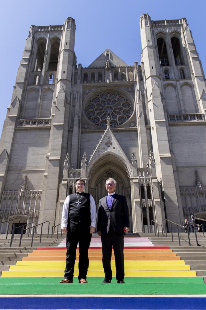 Uskup Megan Rohrer, kiri, dan Uskup Marc Andrus berdiri di tangga pelangi sebelum upacara pelantikan Uskup Rohrer di Katedral Grace di San Francisco, Sabtu, 11 September 2021. Rohrer adalah transgender terbuka pertama yang terpilih sebagai uskup di Gereja Lutheran Injili Amerika. (Foto AP/John Hefti)