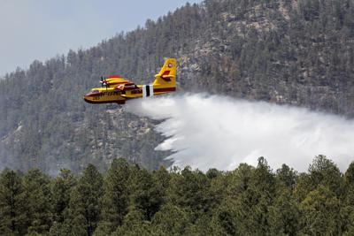 En esta foto publicada por el Servicio Forestal de Estados Unidos, un avión conocido como "super scooper" combate los incendios de Hermits Peak y Calf Canyon en el Bosque Nacional de Santa Fe en Nuevo México el jueves 28 de abril de 2022. (J. Michael Johnson/Servicio Forestal de Estados Unidos vía AP)