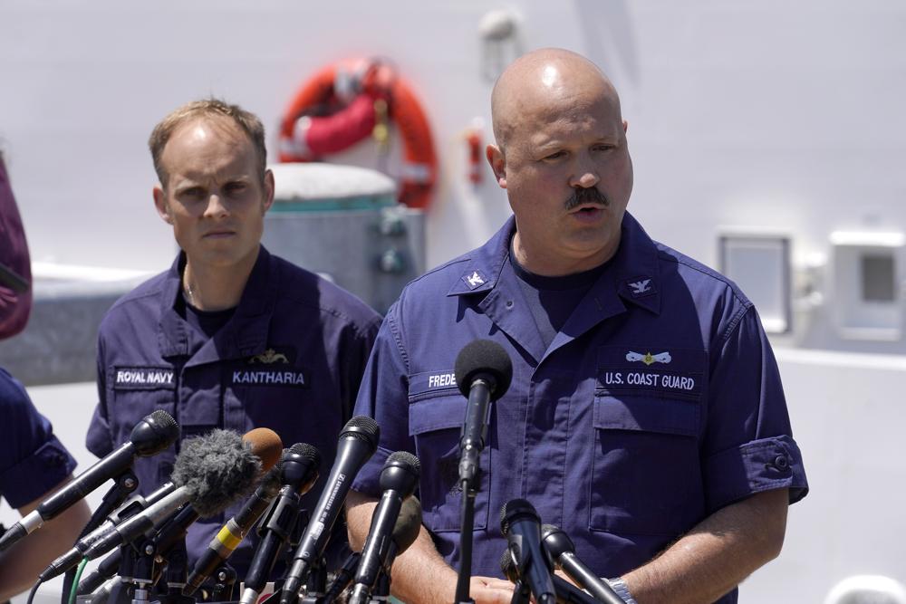 El capitán de la Guardia Costera de EE. UU., Jamie Frederick, a la derecha, se enfrenta a los reporteros mientras el teniente comandante de la Marina Real, Rich Kantharia, a la izquierda, observa durante una conferencia de prensa, el miércoles 21 de junio de 2023, en la base de la Guardia Costera de Boston, en Boston.  La Guardia Costera de EE. UU. dice que se han escuchado sonidos y golpes desde el área de búsqueda del sumergible Titanic.  (Foto AP/Steven Senne)