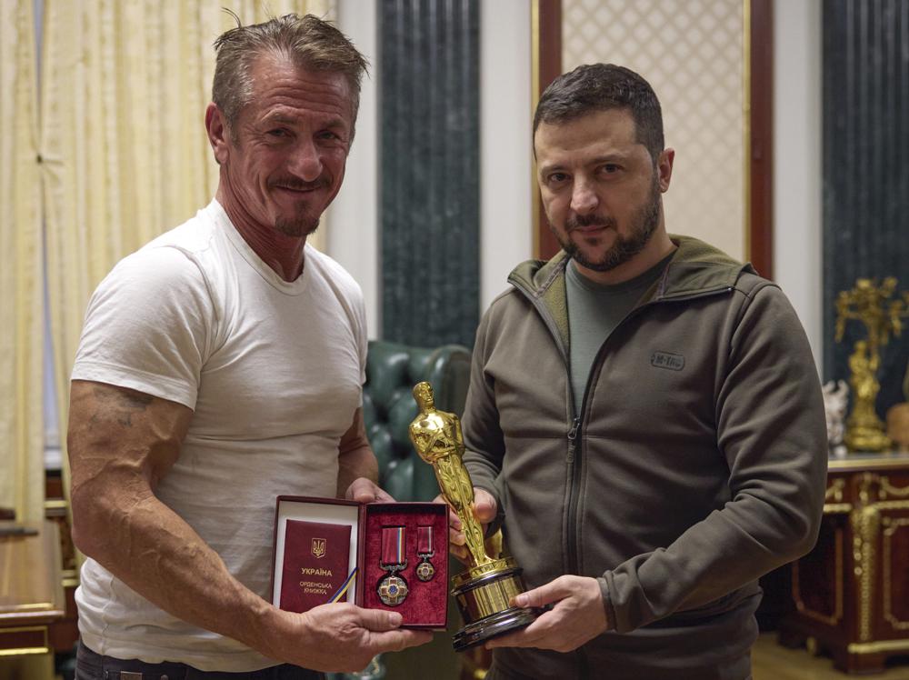 In this photo provided by the Ukrainian Presidential Press Office, Ukrainian President Volodymyr Zelenskyy, right, poses with U.S. actor Sean Penn after receiving latter's Oscar statuette and handing him the Order of Merit, III degree during their meeting in Kyiv, Ukraine, Tuesday, Nov. 8, 2022. (Ukrainian Presidential Press Office via AP)