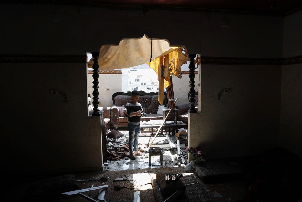 Un niño mira la habitación dañada de su apartamento familiar después de los ataques aéreos israelíes cerca de un edificio residencial, en Beit Lahiya, Franja de Gaza, el jueves 20 de mayo de 2021 (AP Photo / Adel Hana).