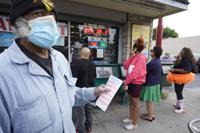 Philip Smith, usa una máscara facial y guantes mientras hace fila para comprar sus boletos de lotería para la lotería Powerball en la tienda Blue Bird Liquor en Hawthorne, California, el lunes 31 de octubre de 2022. El premio mayor para el sorteo del lunes por la noche se disparó después de que nadie igualó los seis números en el sorteo del sábado por la noche. Es el quinto premio mayor de lotería más grande en la historia de los Estados Unidos. (AP Foto/Damián Dovarganes)