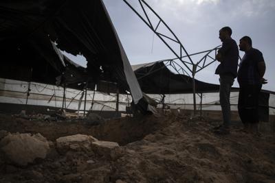 Palestinos observan los daños causados a una granja avícola tras los ataques aéreos israelíes en la localidad de Rafah, en el sur de la Franja de Gaza, el domingo 12 de septiembre de 2021. (AP Foto/Khalil Hamra)