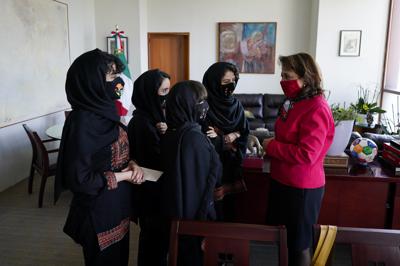 Martha Delgado, subsecretaria de Asuntos Multilaterales y Derechos Humanos de la Secretaría de Relaciones Exteriores de México, conversa con miembros del equipo de robótica femenino afgano luego de una entrevista en la Ciudad de México, el miércoles 25 de agosto de 2021. (AP Foto/Eduardo Verdugo)