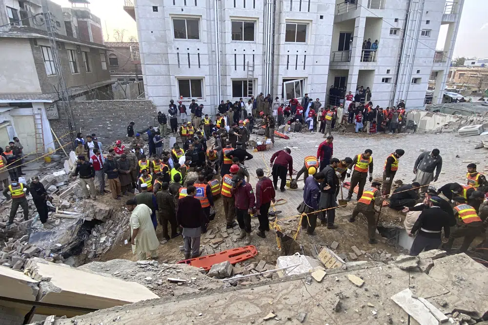 Security officials and rescue workers search bodies at the site of suicide bombing, in Peshawar, Pakistan, Monday, Jan. 30, 2023. (AP Photo/Zubair Khan)