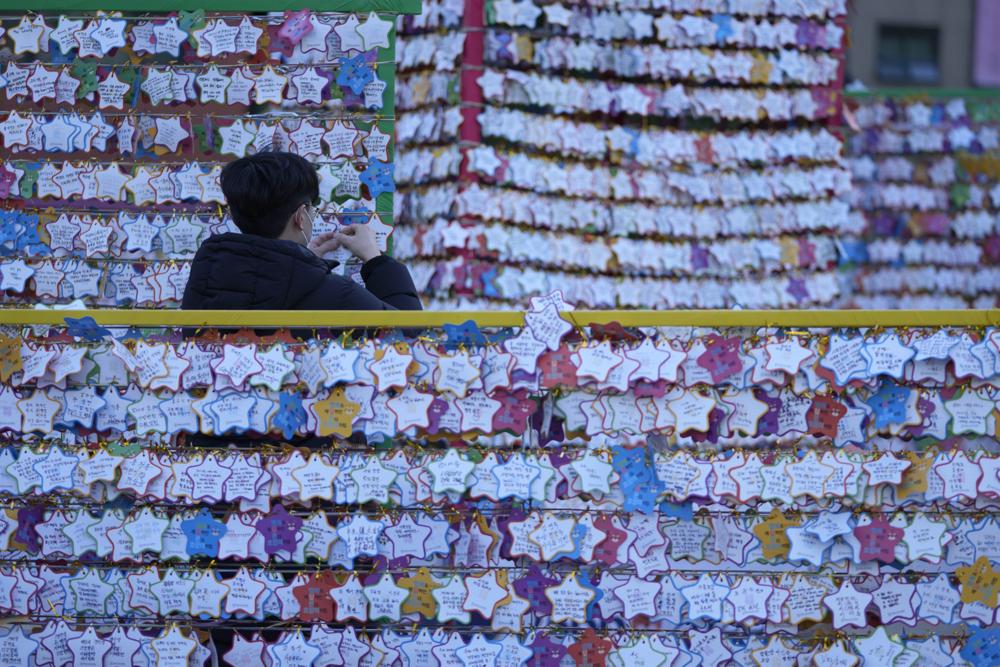 Un hombre cuelga una nota de papel con sus deseos de Año Nuevo en la víspera de Año Nuevo en el templo Jogye en Seúl, Corea del Sur, el viernes 31 de diciembre de 2021 (AP Photo / Lee Jin-man).